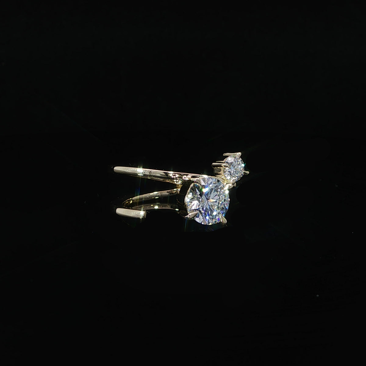 Close-up of the curved gold band beneath the two round diamonds.
