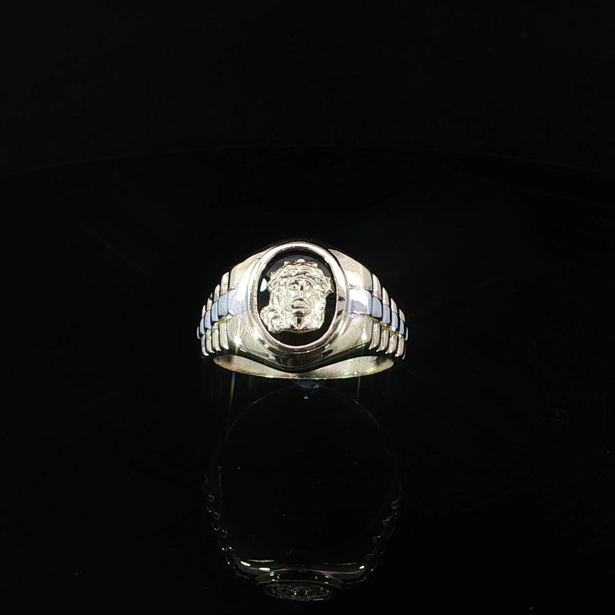 Front elevated view of a 14K yellow gold two-tone Jesus signet ring featuring a Crown of Thorns portrait within an oval black centerpiece and ribbed shoulders.