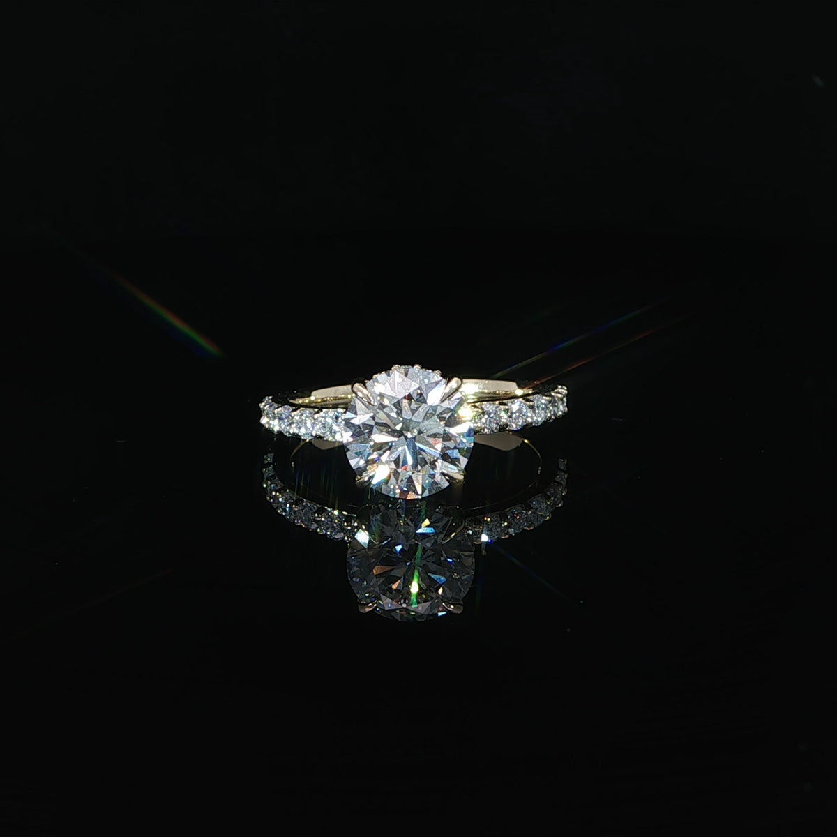 Front view of a round diamond engagement ring featuring a hidden halo and yellow gold diamond band.