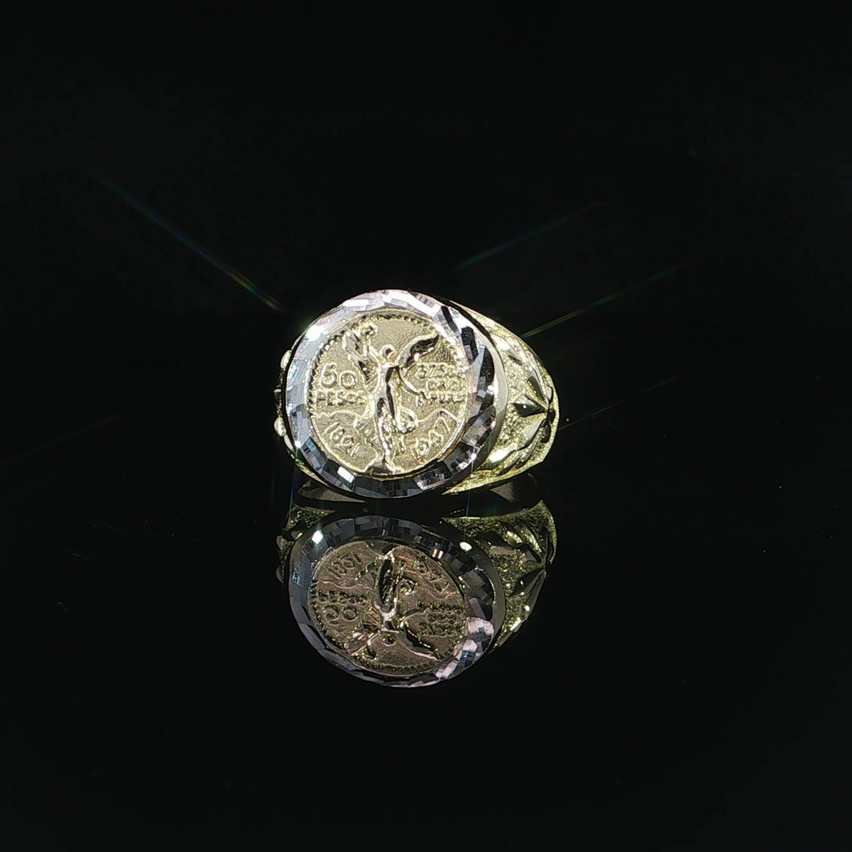 A 17mm Centenario-inspired ring face featuring a raised winged figure, decorative lettering and contrasting white accents.