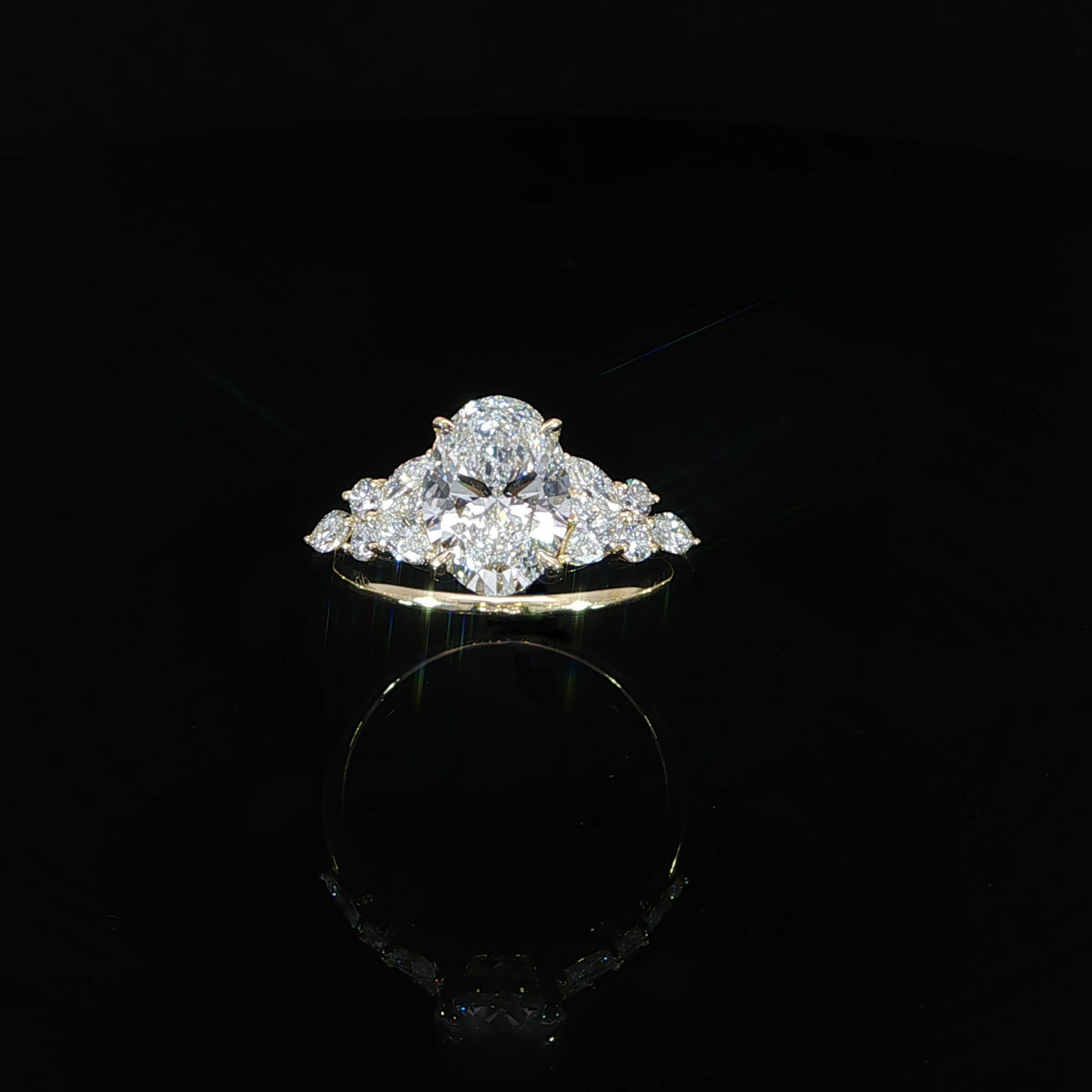 Angled view of a 2 carat oval lab grown diamond ring in 14K yellow gold with decorative side diamonds.
