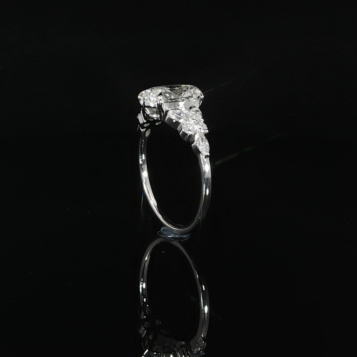 Side view of a 2 carat oval lab grown diamond ring showing the elevated center stone setting and white gold band.