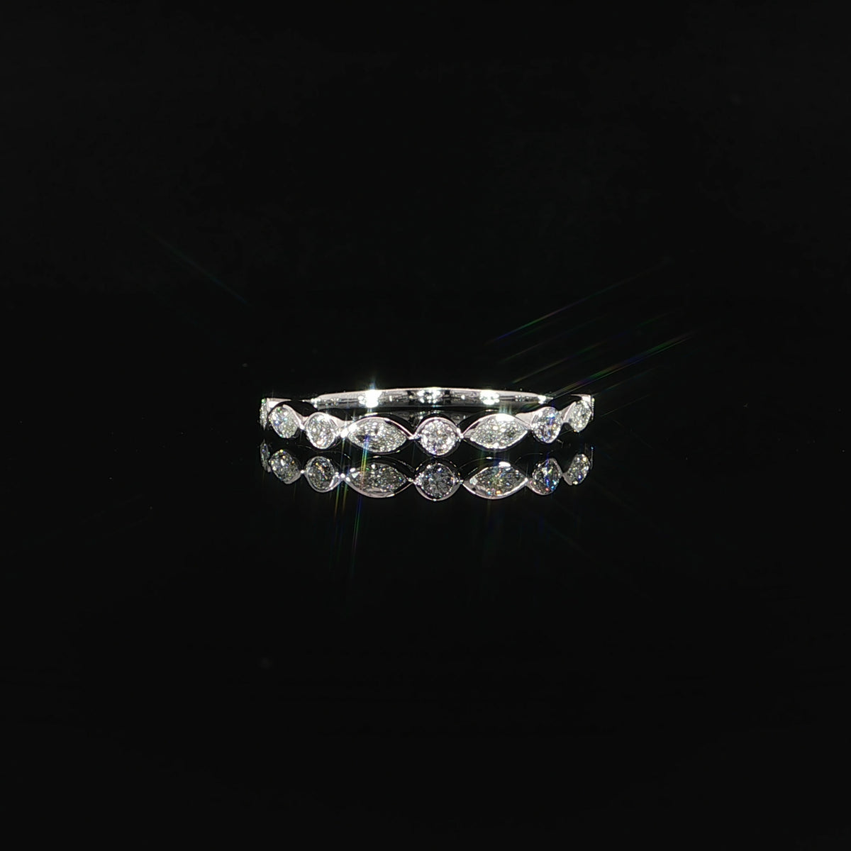 Front view of a 14K white gold band with alternating marquise and round bezel-set diamonds.