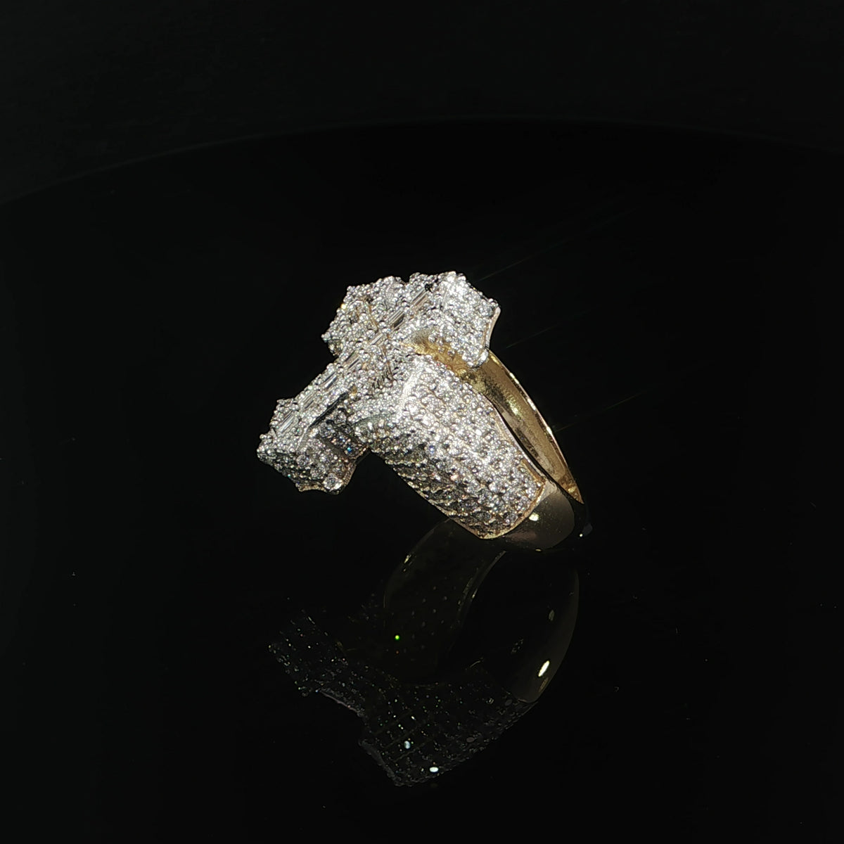 Angled view showing baguette diamonds along the cross and round diamonds covering the shoulders.