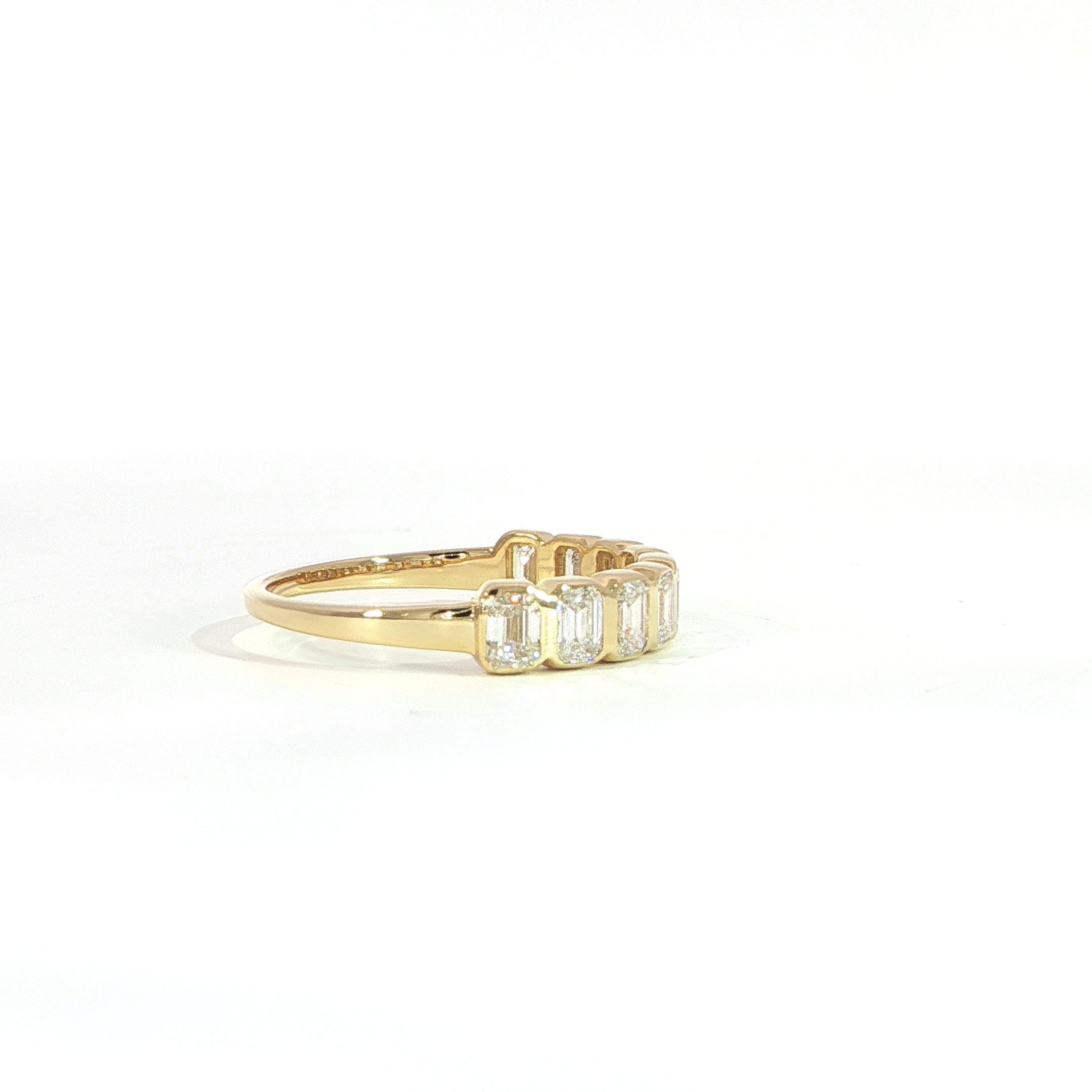 Modern emerald diamond eternity band with bezel setting side view