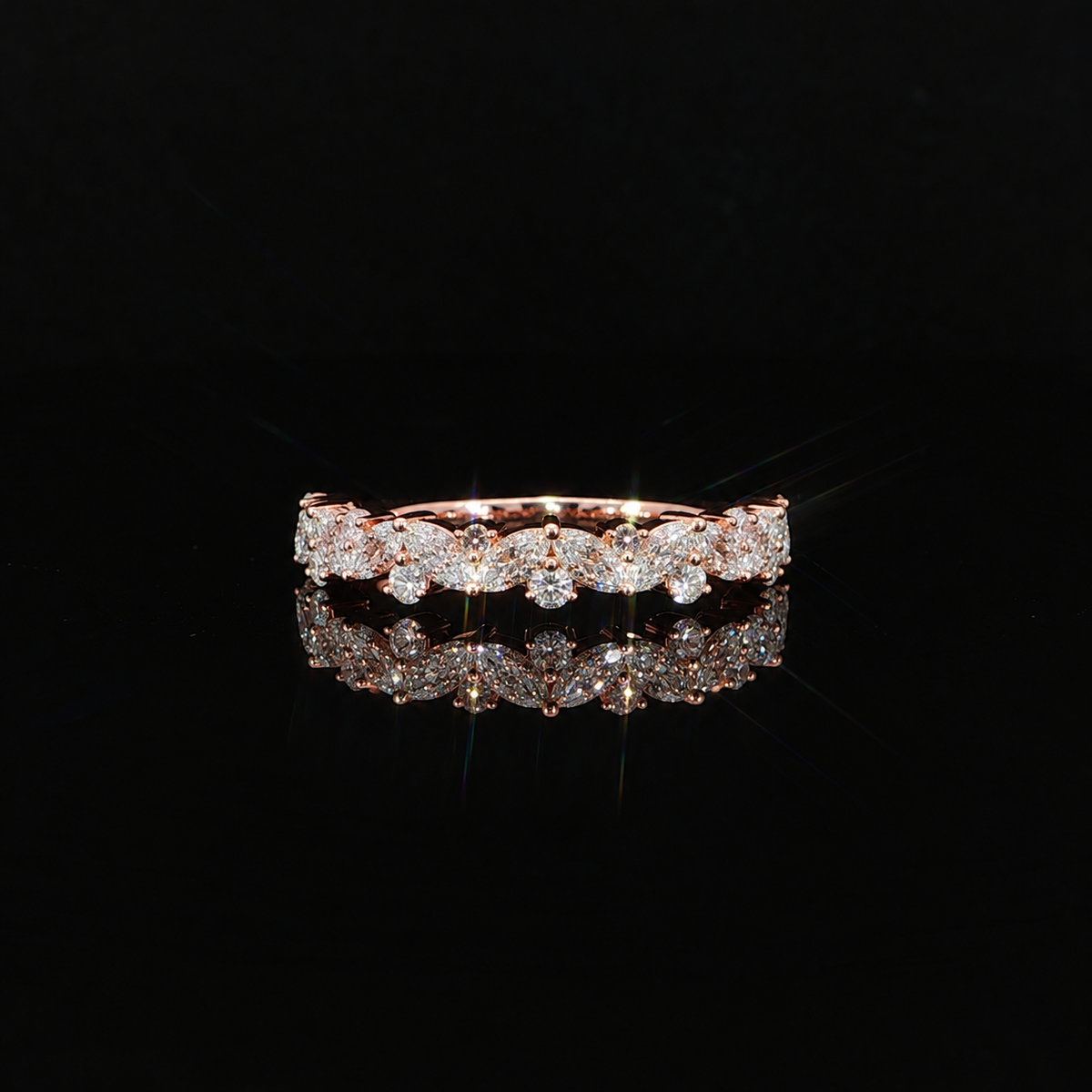 Close up view of rose gold diamond band with marquise and round stones.