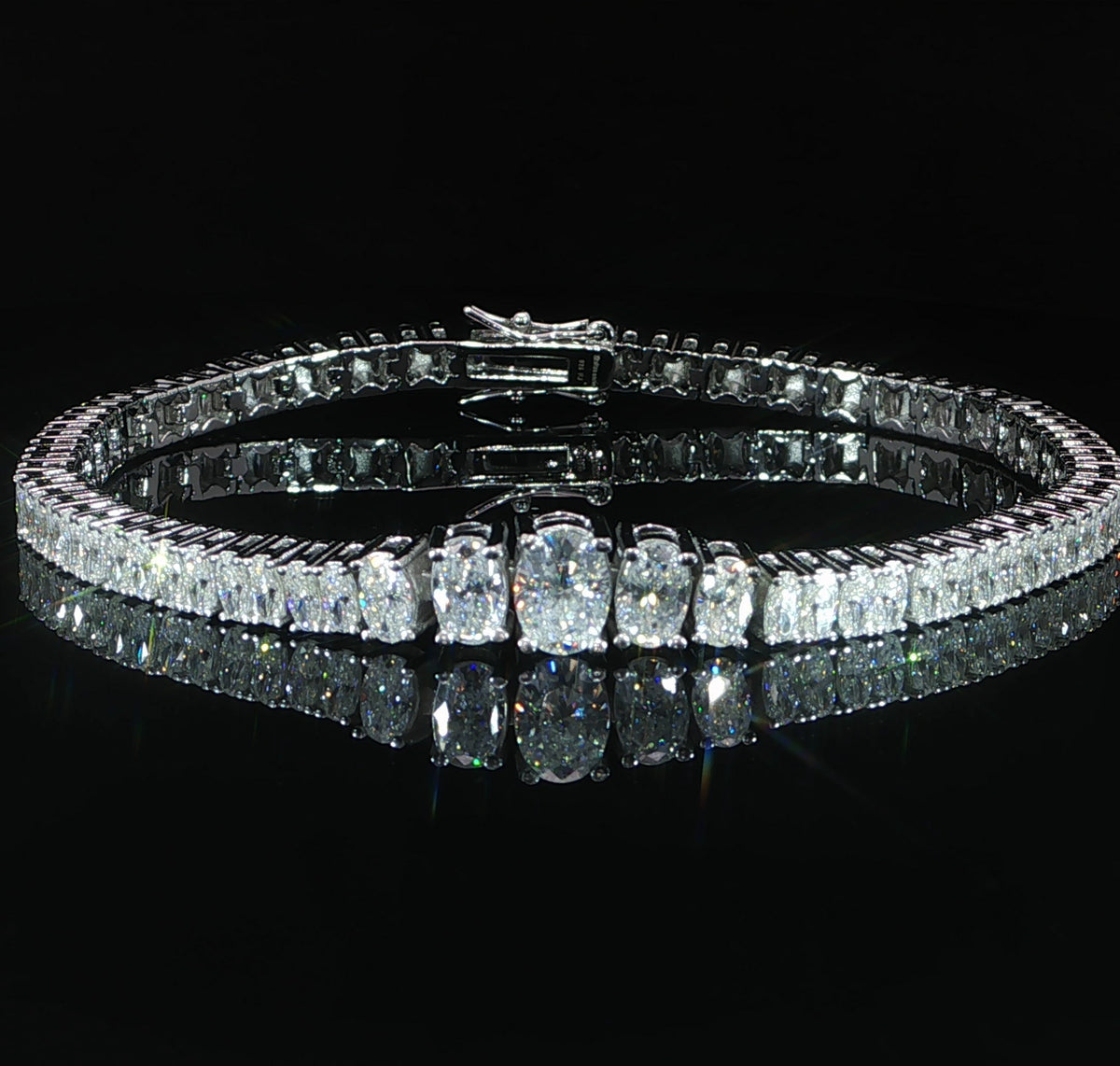 Graduated tennis bracelet featuring a 7.5 mm oval moissanite center in 925 sterling silver