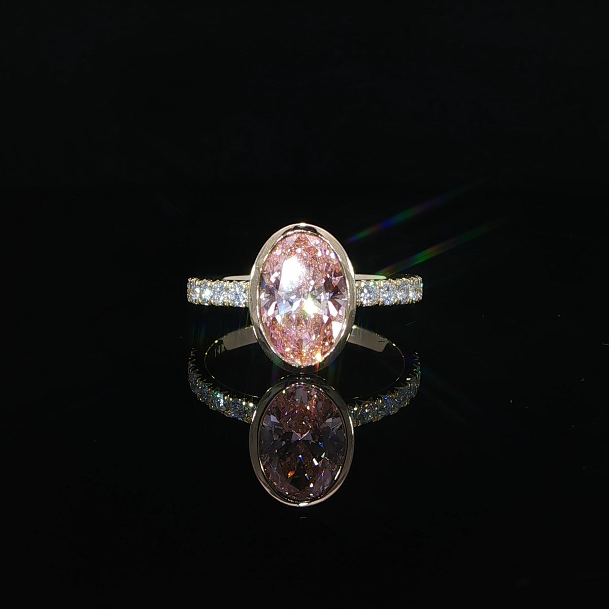 Front view of 2CT pink diamond surrounded by 14k yellow gold and pave diamond band