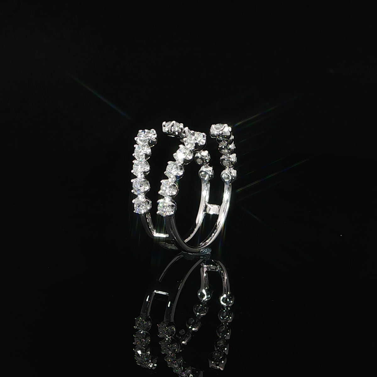 Upright view of a 14K white gold ring guard with two curved rows of round diamonds graduating toward the open ends.