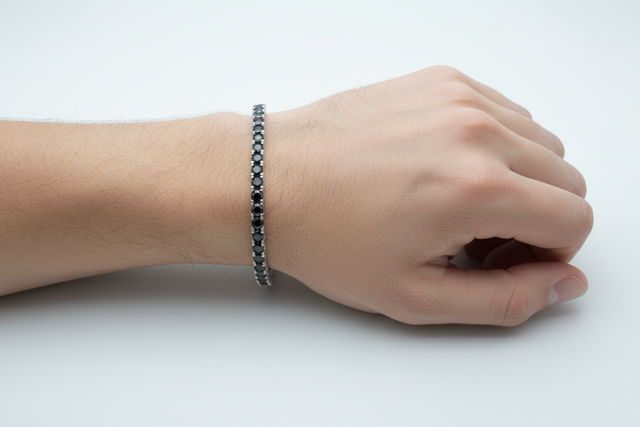 Hand model wearing 3MM black moissanite tennis bracelet in polished sterling silver.