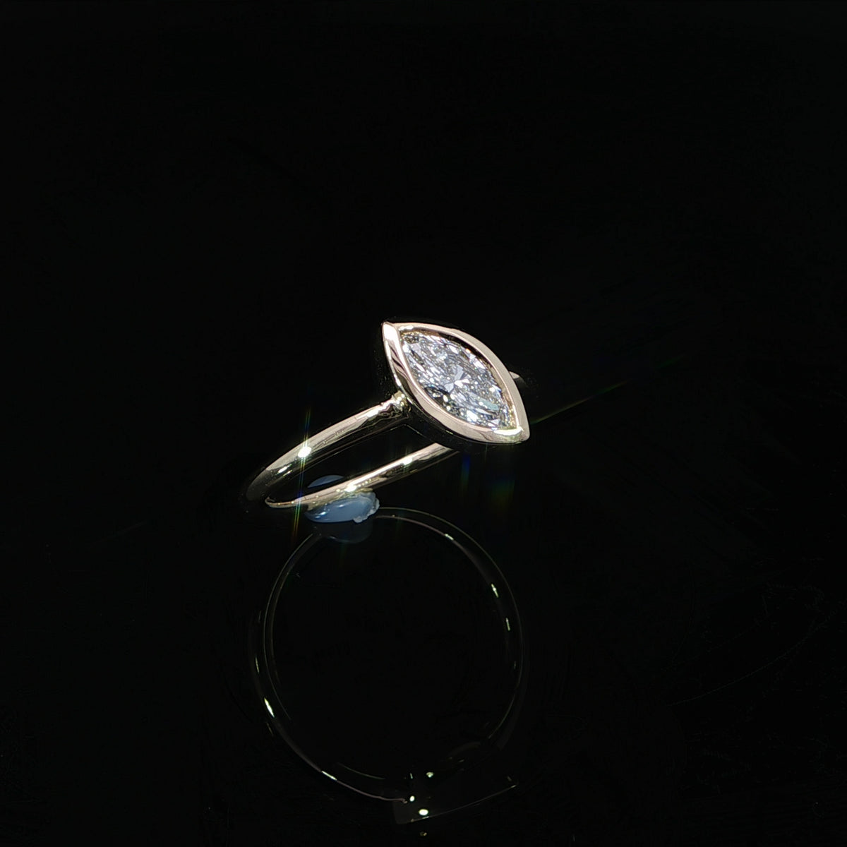Front view of a marquise bezel set diamond engagement ring in polished 14K yellow gold.