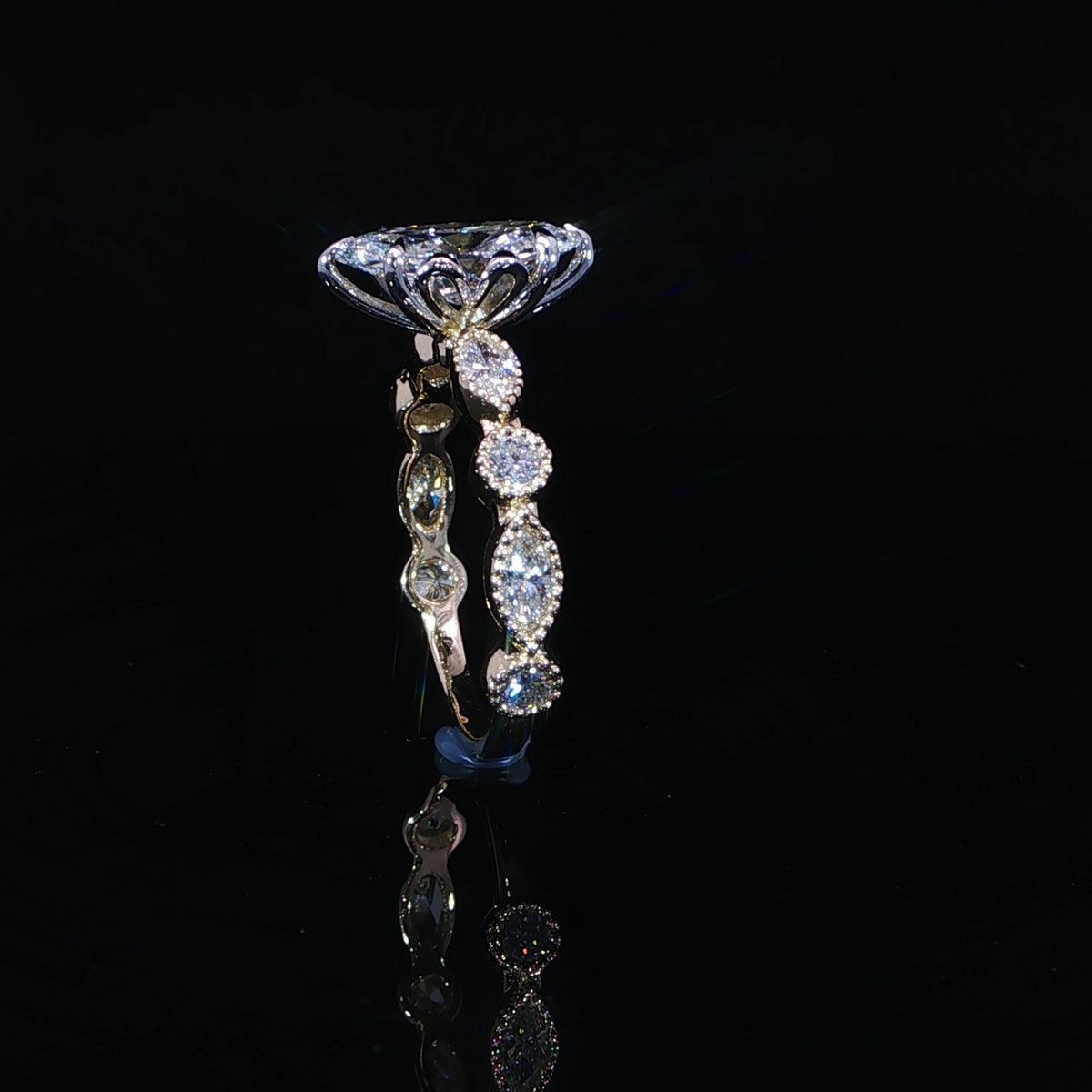 Standing side view of a marquise diamond ring showing its sculpted gallery and milgrain band
