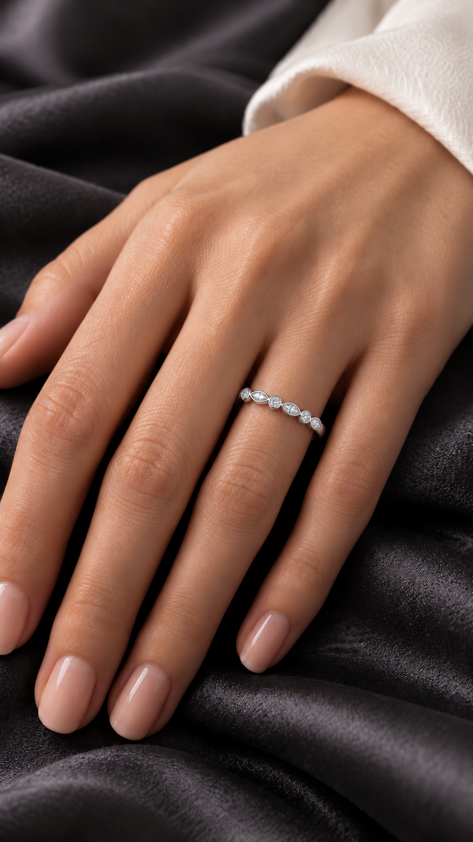 Hand showing white gold diamond ring with round and marquise diamonds