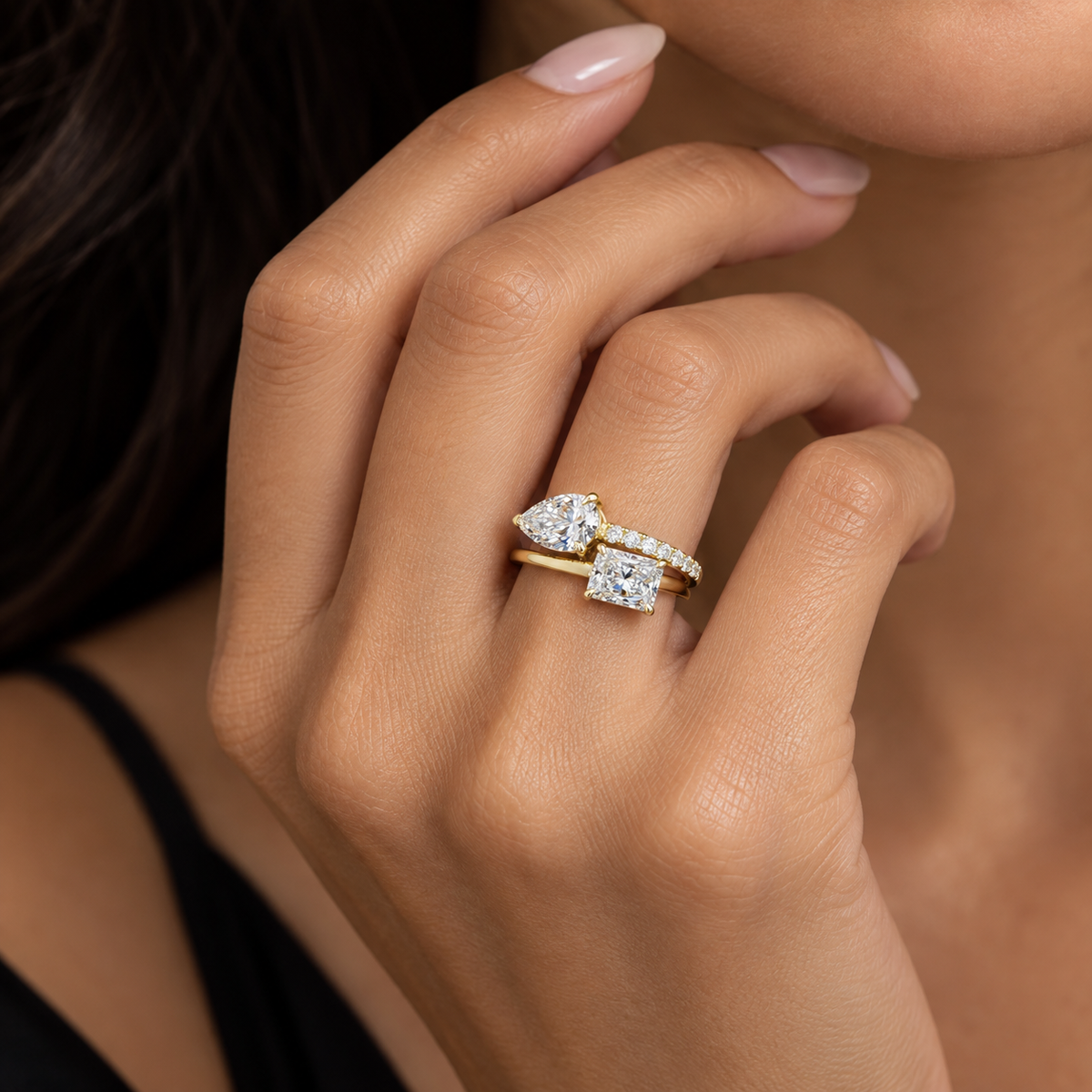 Model wearing 14K yellow gold Toi et Moi ring with F-G color VS-VVS lab grown radiant and pear diamonds