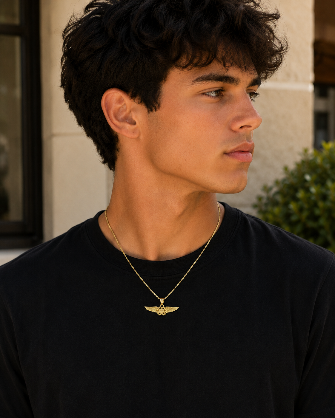 Military-inspired gold pendant featuring detailed wings and shield