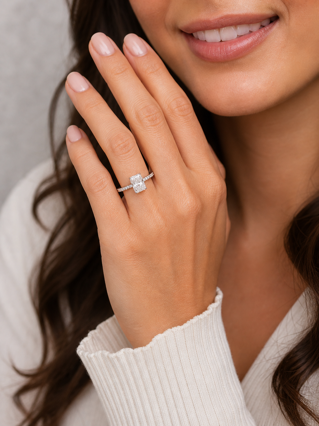 Model wearing radiant diamond engagement ring with hidden halo