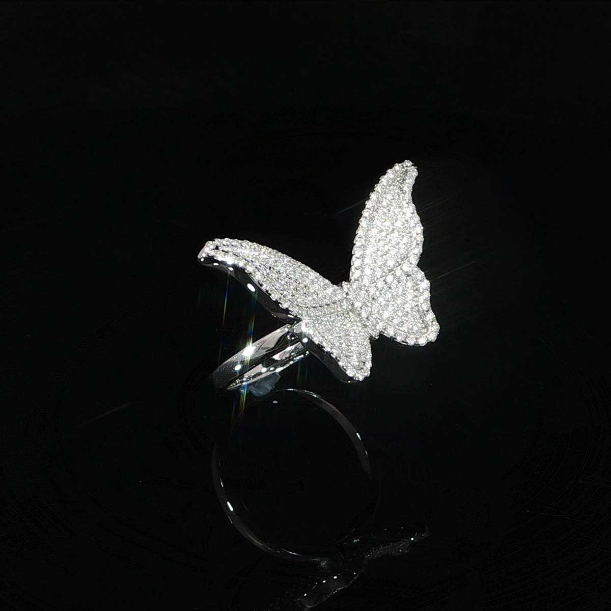 Angled view of a sterling silver butterfly ring showing its raised wings and moissanite surface