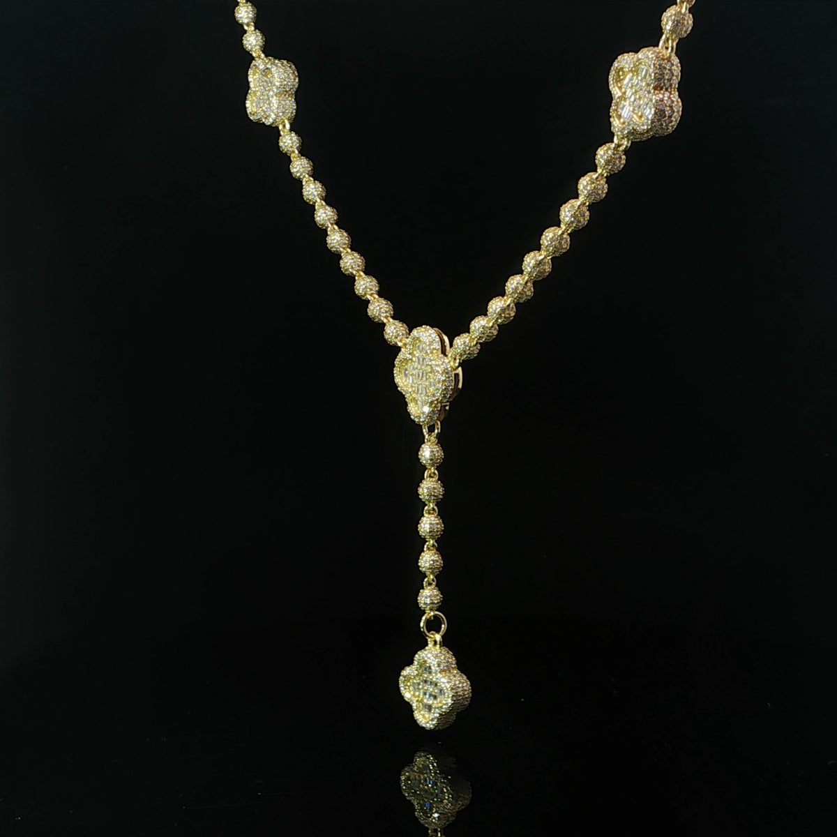 Moissanite clover lariat necklace displayed against a black background
