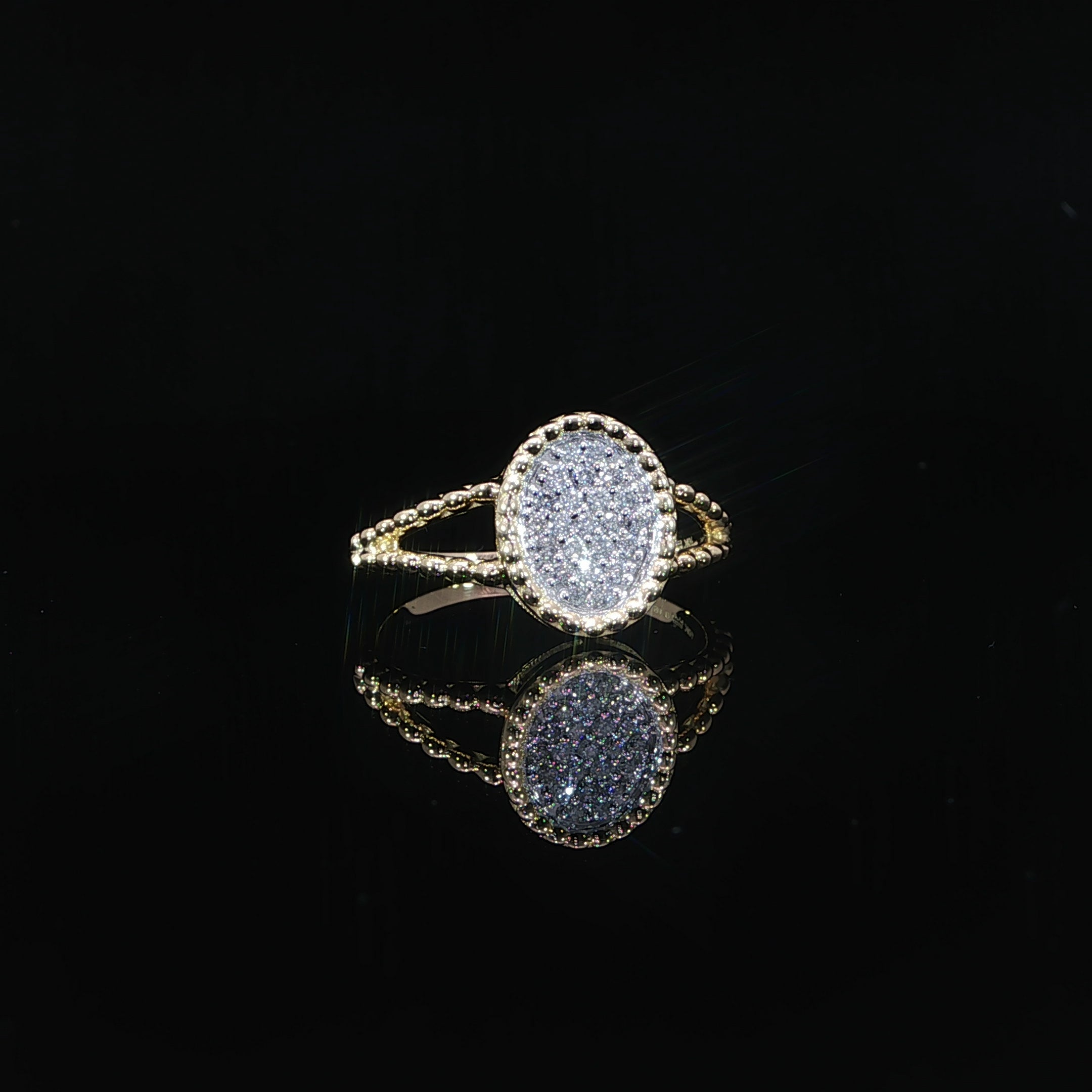 Natural diamond cluster ring with oval-shaped center and beaded gold border