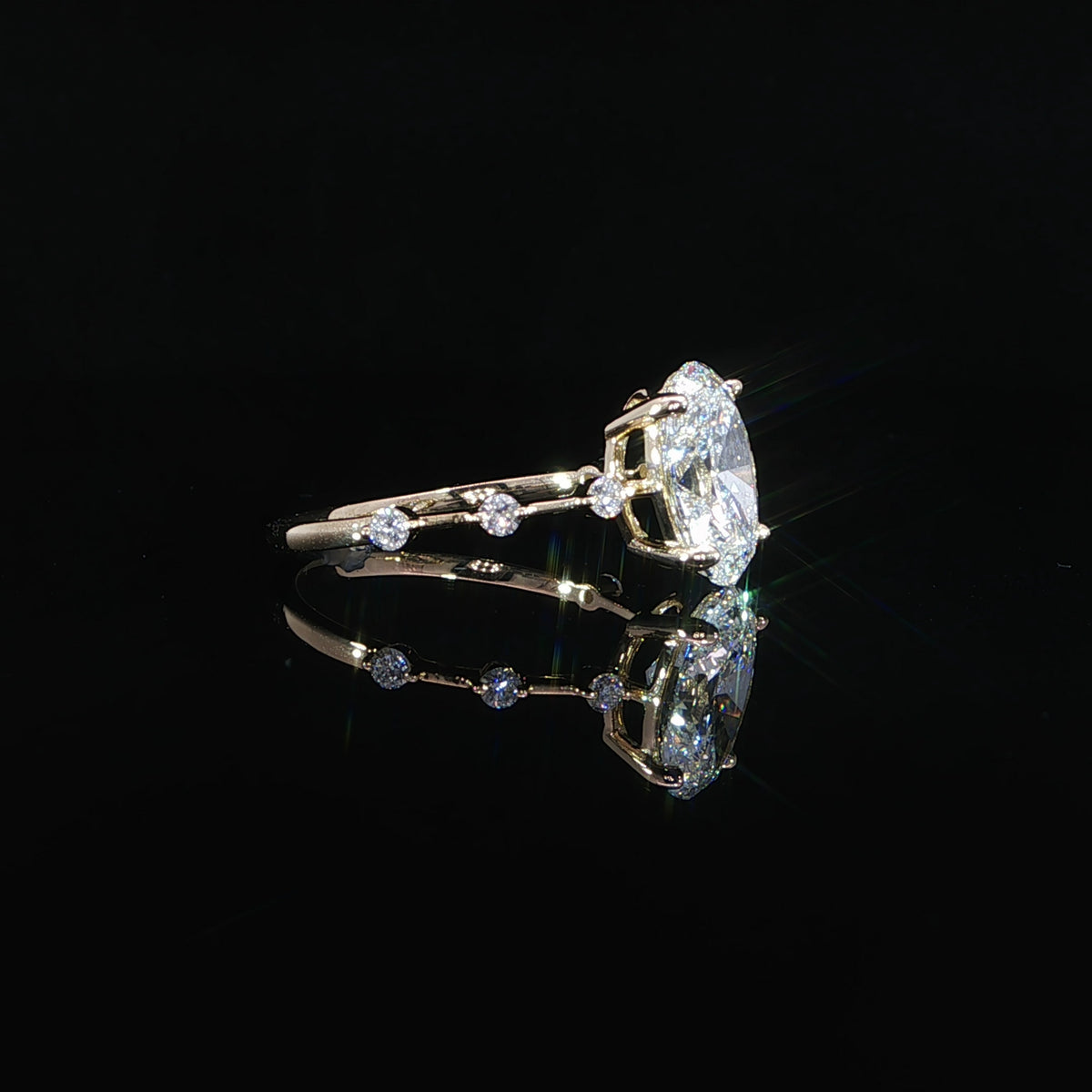 Side profile of a yellow gold oval diamond engagement ring showing its elevated center setting.