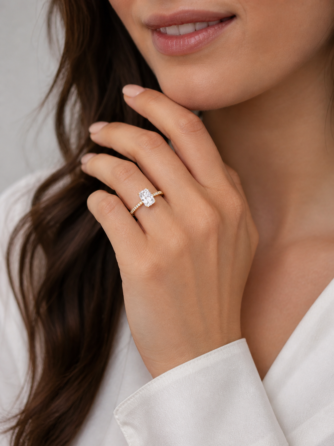 Model wearing 14K gold radiant diamond ring with sparkling pavé band