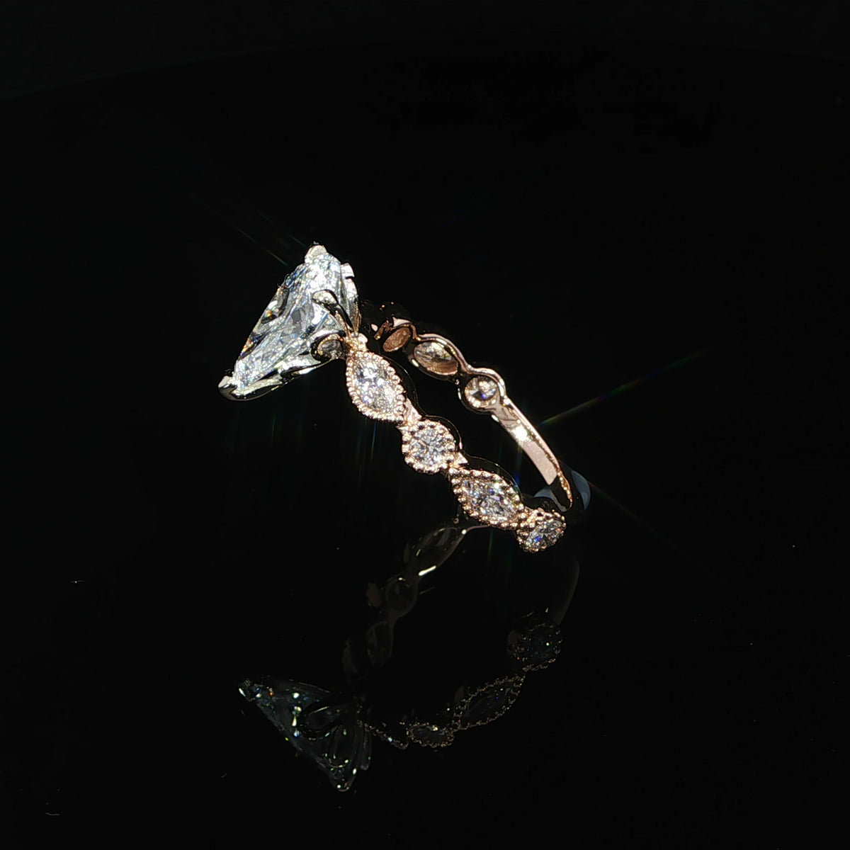 Pear lab grown diamond engagement ring with mixed-shape bezel set side stones in 14K rose gold.