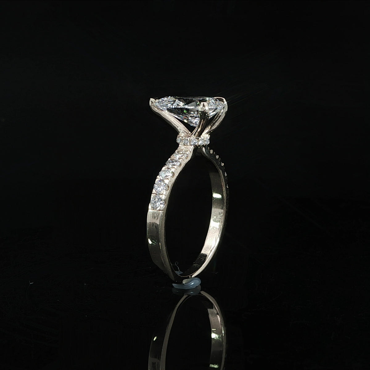 Side profile of a pear lab-grown diamond engagement ring showing its elevated center-stone setting.