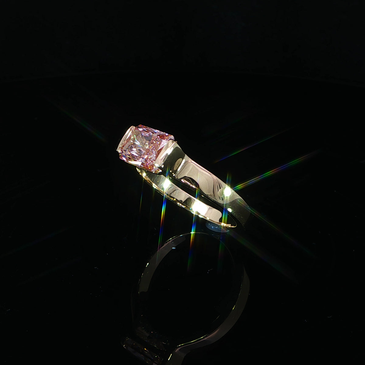 East-west yellow gold ring with 2.20 CTW of lab grown diamonds and a vivid pink radiant center stone.