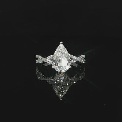 Modern pear-shaped diamond engagement ring with a flowing twist band and hidden halo.