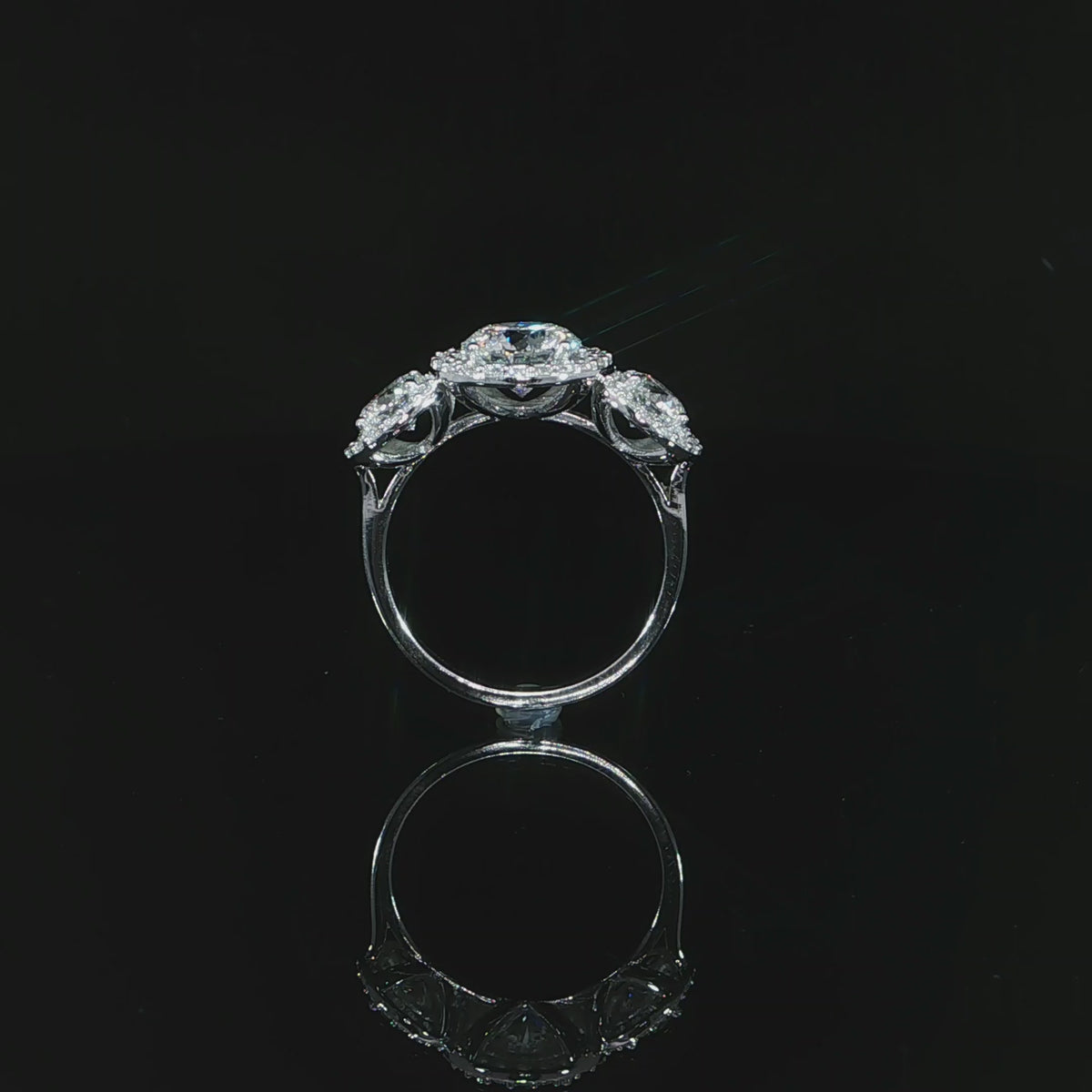 Video of 14k white gold three-stone diamond ring showing the open gallery and polished band