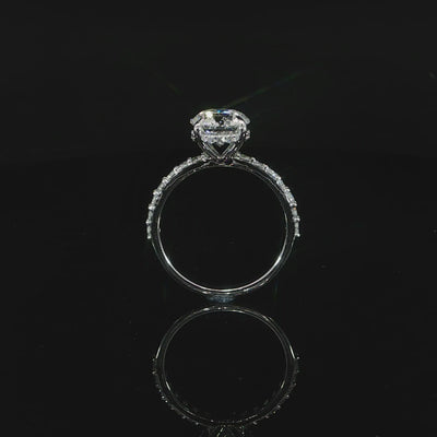 Close video of the diamond-accented white gold band supporting the round center stone.