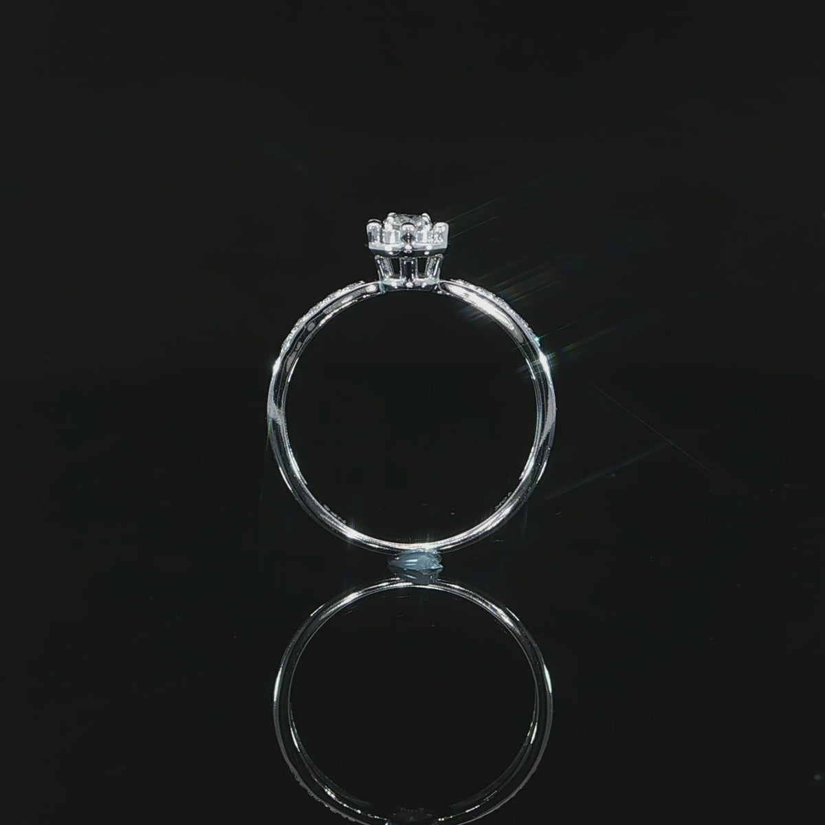 Video of a 10K white gold 0.22 CTW natural diamond illusion ring showing its raised setting and circular band.