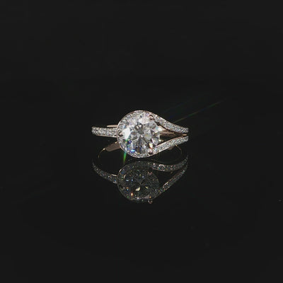 Profile view of a 1.54 carat round diamond engagement ring with an open bypass design and pavé band.