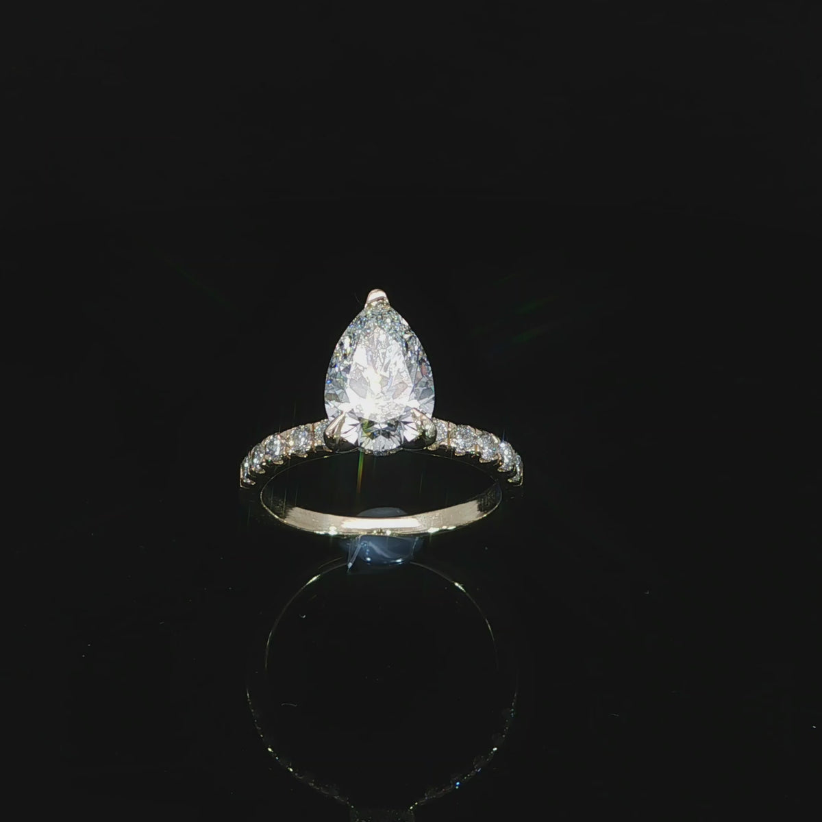 Yellow gold engagement ring featuring an E color, VVS2 clarity pear-shaped lab-grown center diamond.