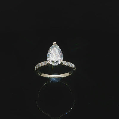 Yellow gold engagement ring featuring an E color, VVS2 clarity pear-shaped lab-grown center diamond.