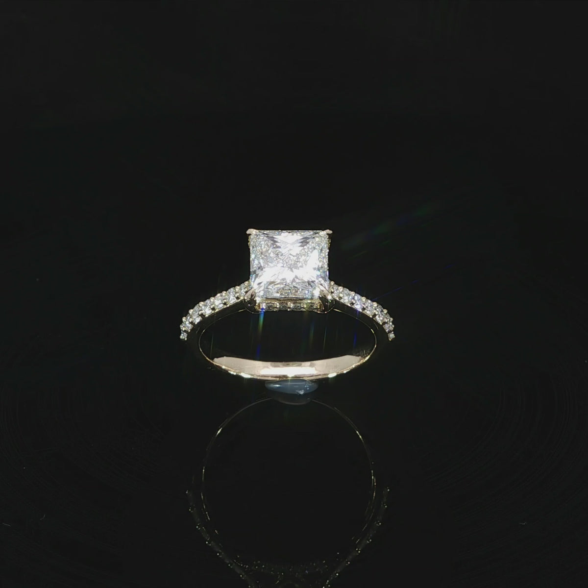 2.46 CTW lab grown diamond engagement ring with a princess cut center stone and pavé accents in 14K yellow gold.