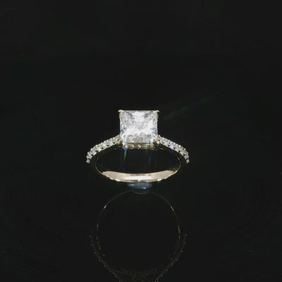 2.46 CTW lab grown diamond engagement ring with a princess cut center stone and pavé accents in 14K yellow gold.