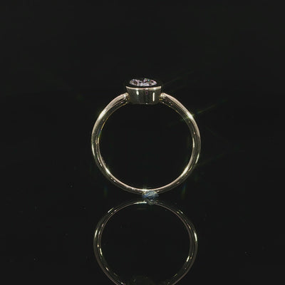 Minimalist 14K yellow gold engagement ring with a bezel set oval lab grown diamond.