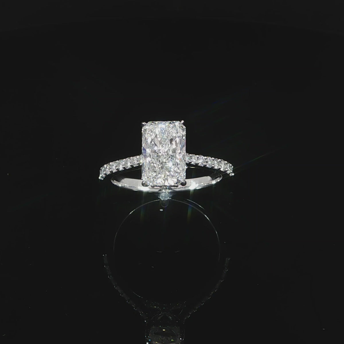Radiant-cut hidden halo engagement ring photographed against a black background.