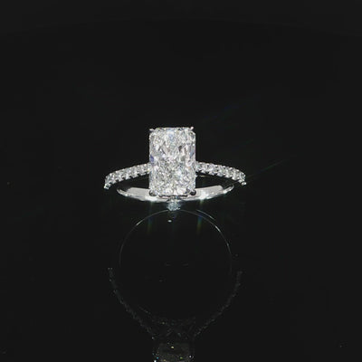 Radiant-cut hidden halo engagement ring photographed against a black background.