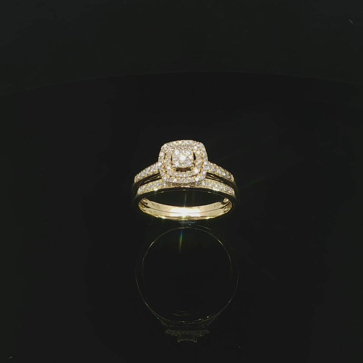 Angled video of a 10K yellow gold double-halo ring alongside its matching diamond wedding band.