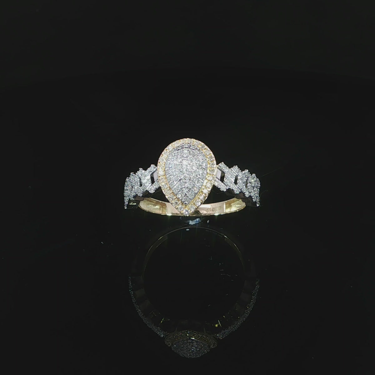 Angled video of a 10K yellow gold 0.38 CTW pear cluster halo ring, with the head to the left and band extending right.