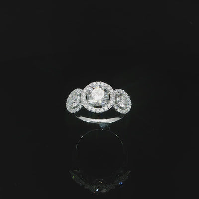 Video of three-stone arrangement with a larger round center and two halo-framed side stones