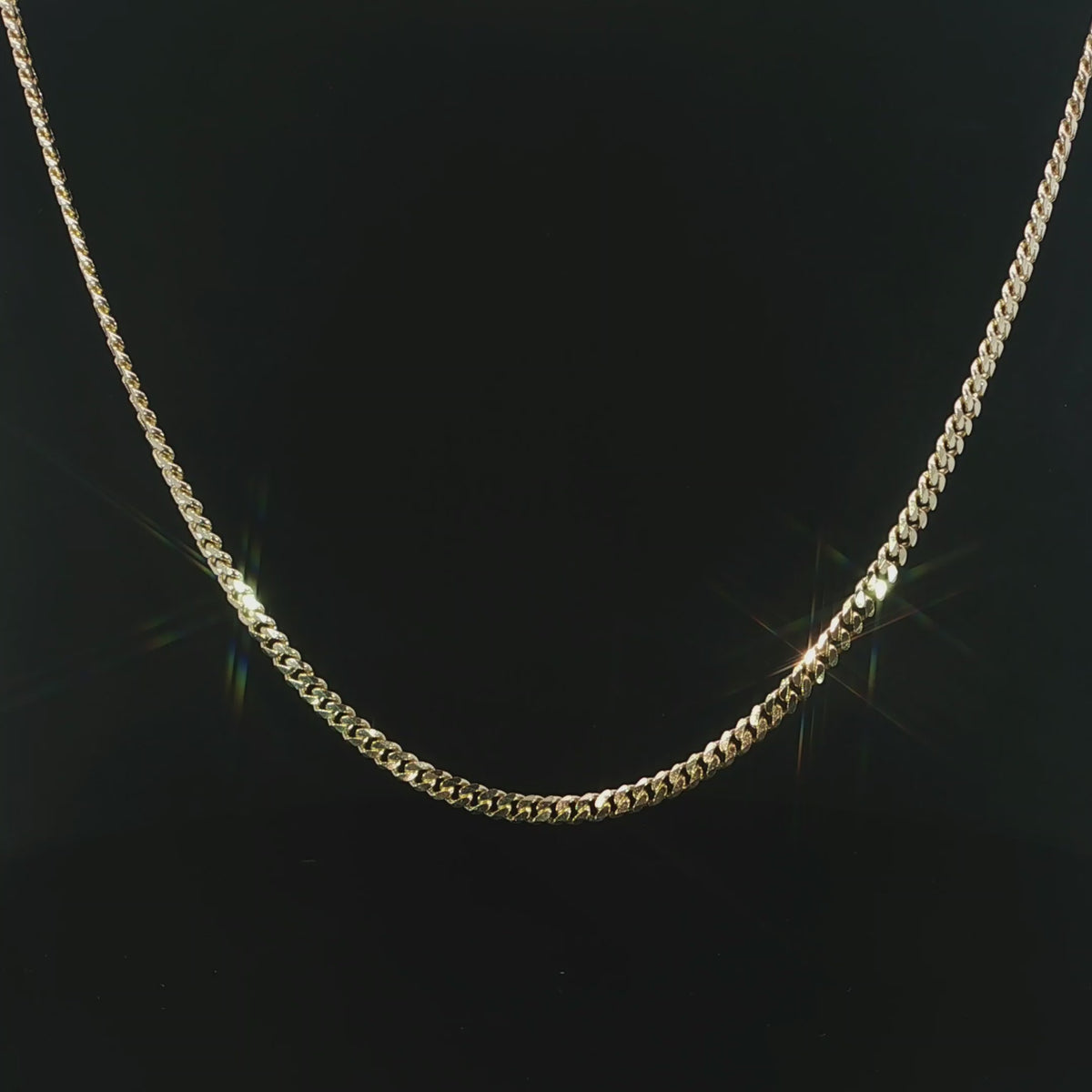 Polished yellow gold Miami Cuban necklace displayed against a black background