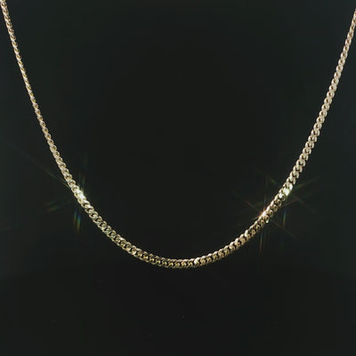 Polished yellow gold Miami Cuban necklace displayed against a black background