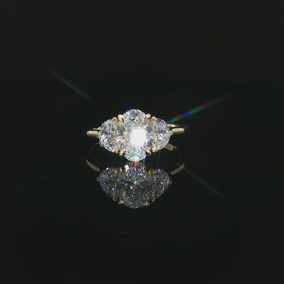 Detailed video of the 1.52-carat oval center diamond between two half-moon side stones.