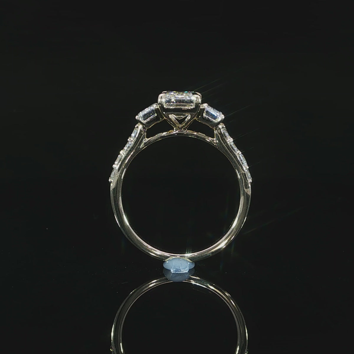 Yellow gold three-stone engagement ring with 3.10 CTW of lab grown emerald cut diamonds and pavé accents.