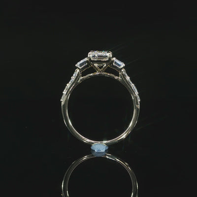 Yellow gold three-stone engagement ring with 3.10 CTW of lab grown emerald cut diamonds and pavé accents.