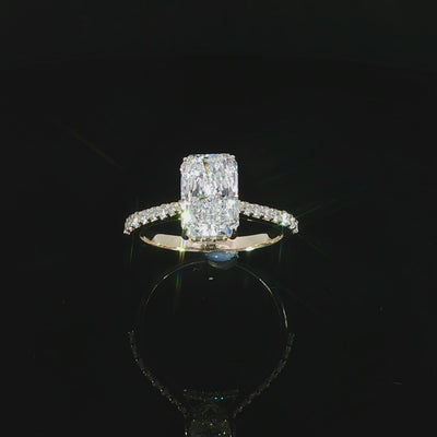 Diamond-set bridge beneath the center setting of a yellow gold radiant ring