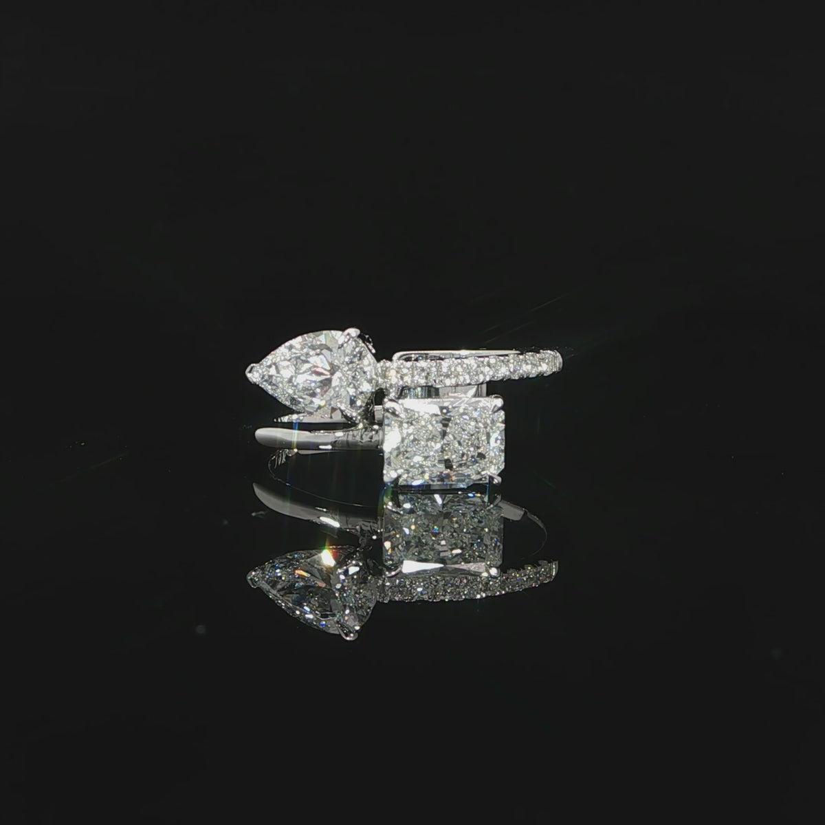 Asymmetrical Toi et Moi ring with radiant and pear shaped lab grown diamonds in a modern two-stone setting.